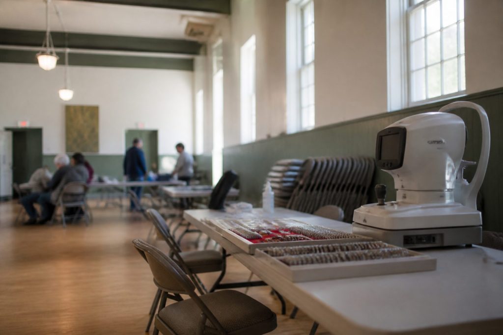A community hall set up with tables and screening equipment for a volunteer vision screening event
